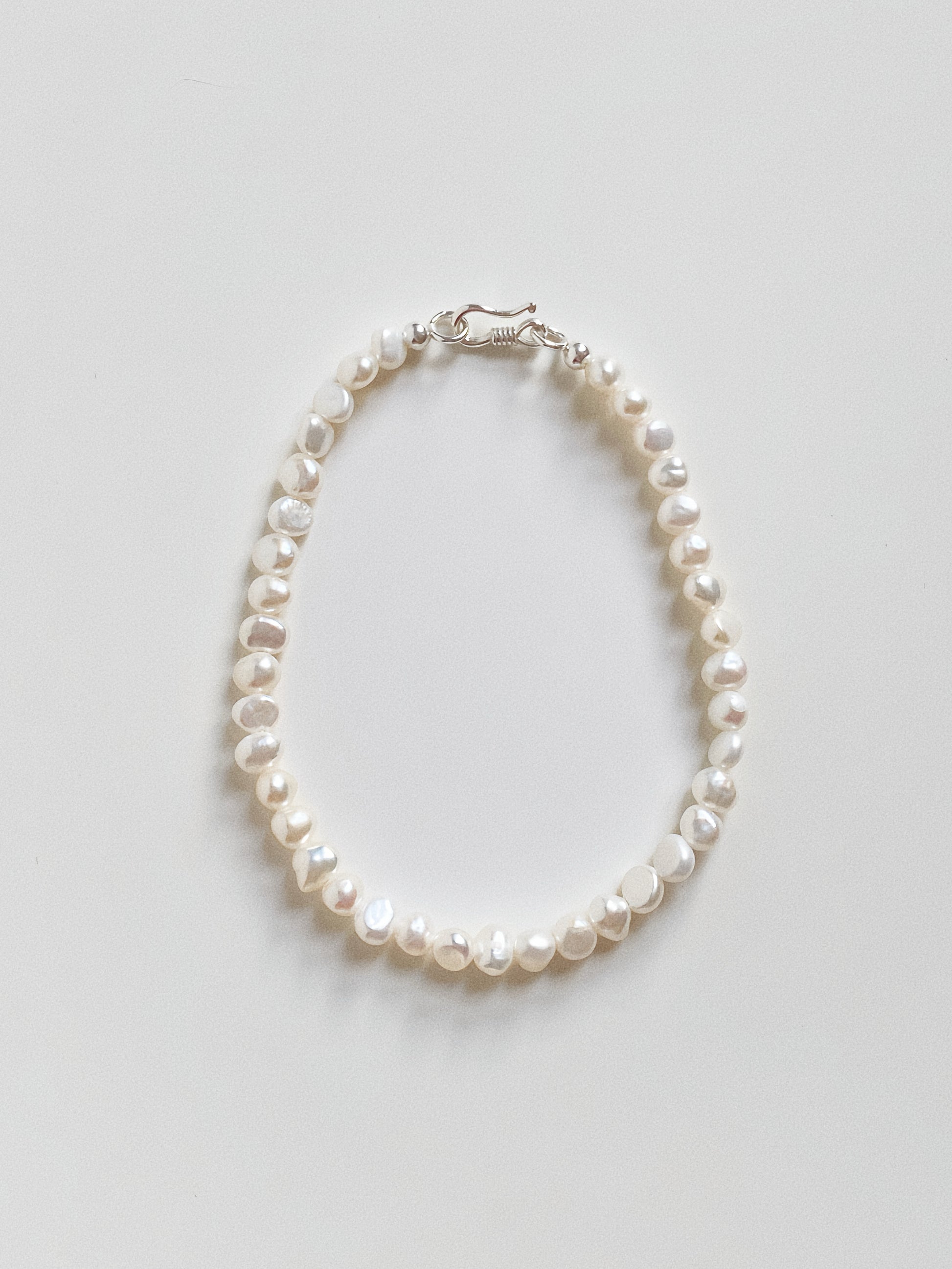 Top down view of the mini baroque pearl bracelet, highlighting the natural irregular shape of the gems.