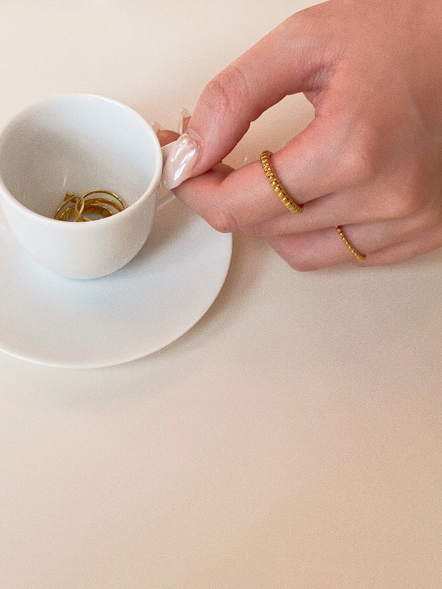 Detailed view of the narrow gold beaded ring on a finger, highlighting its minimalist fit.