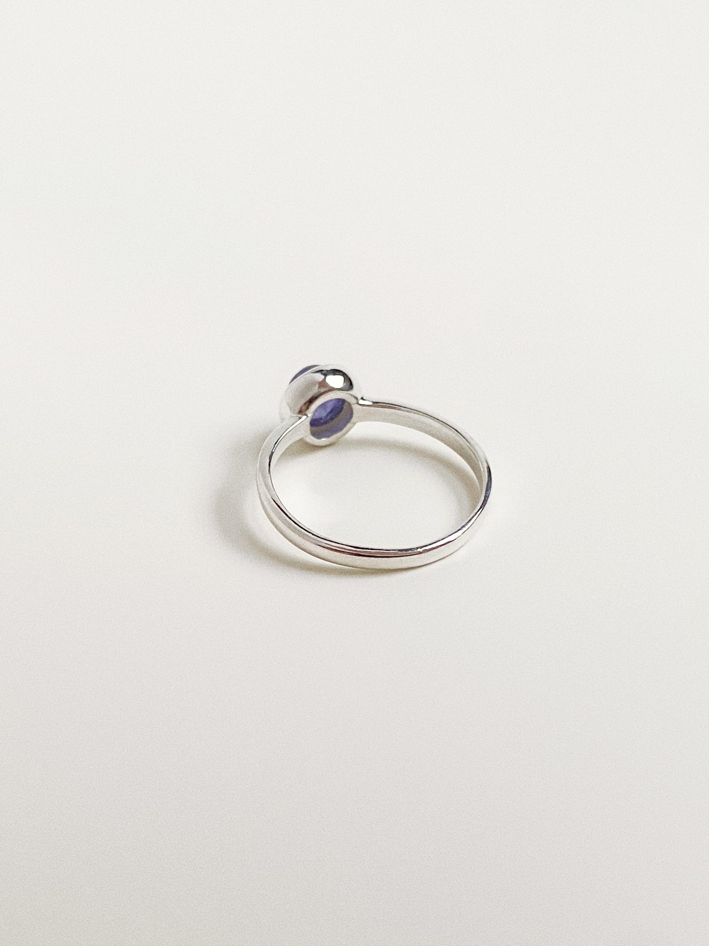 Side profile of the silver ring band showing the high polish finish and simple bezel setting construction.