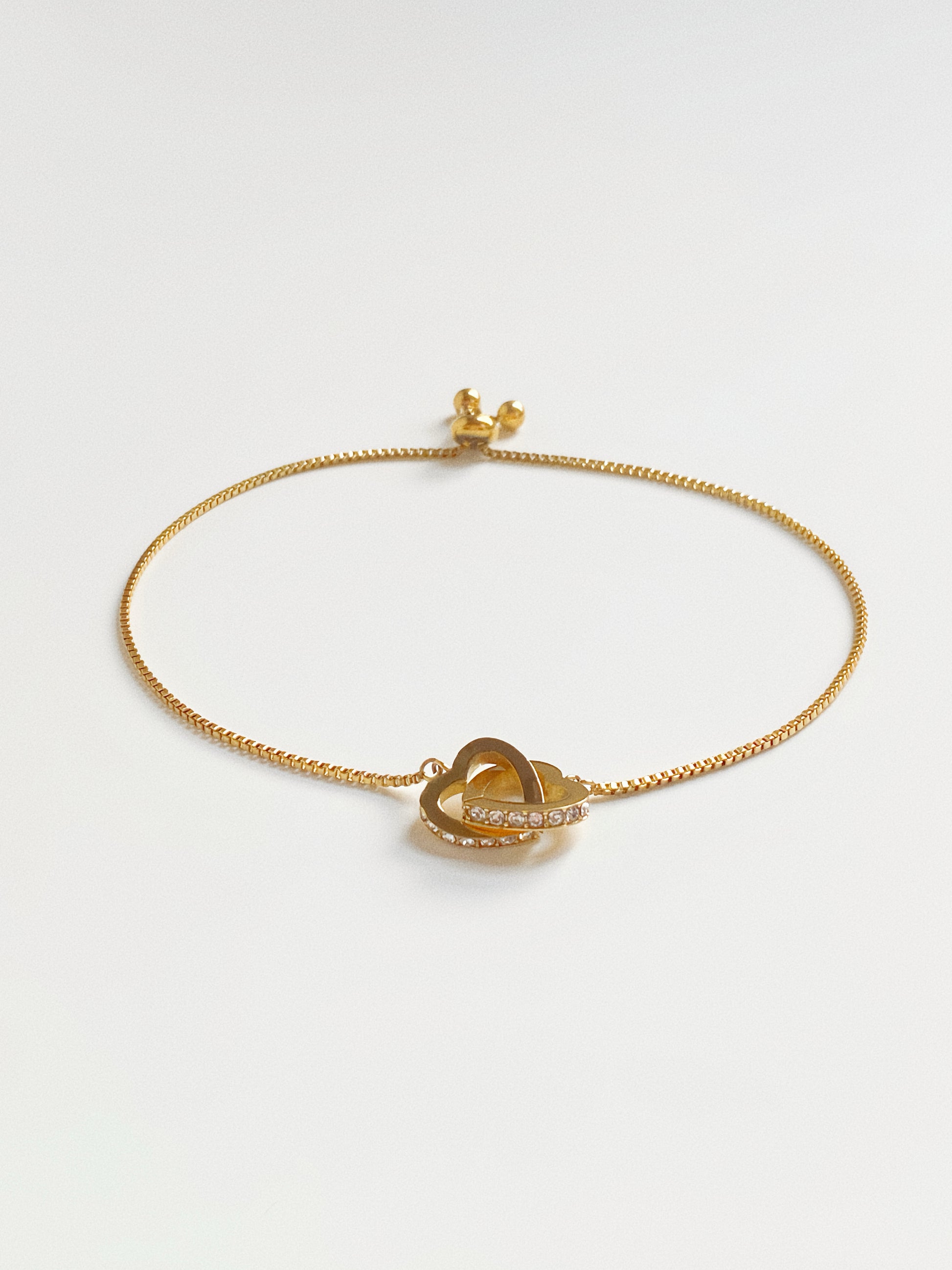 Full view of gold connected hearts slider bracelet showing the maximum 24cm adjustable length.