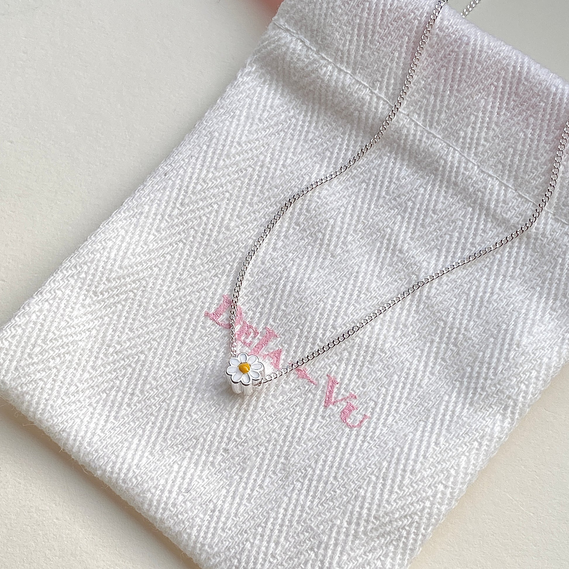 Daisy enamel necklace displayed with Deja vu jewellery pouch