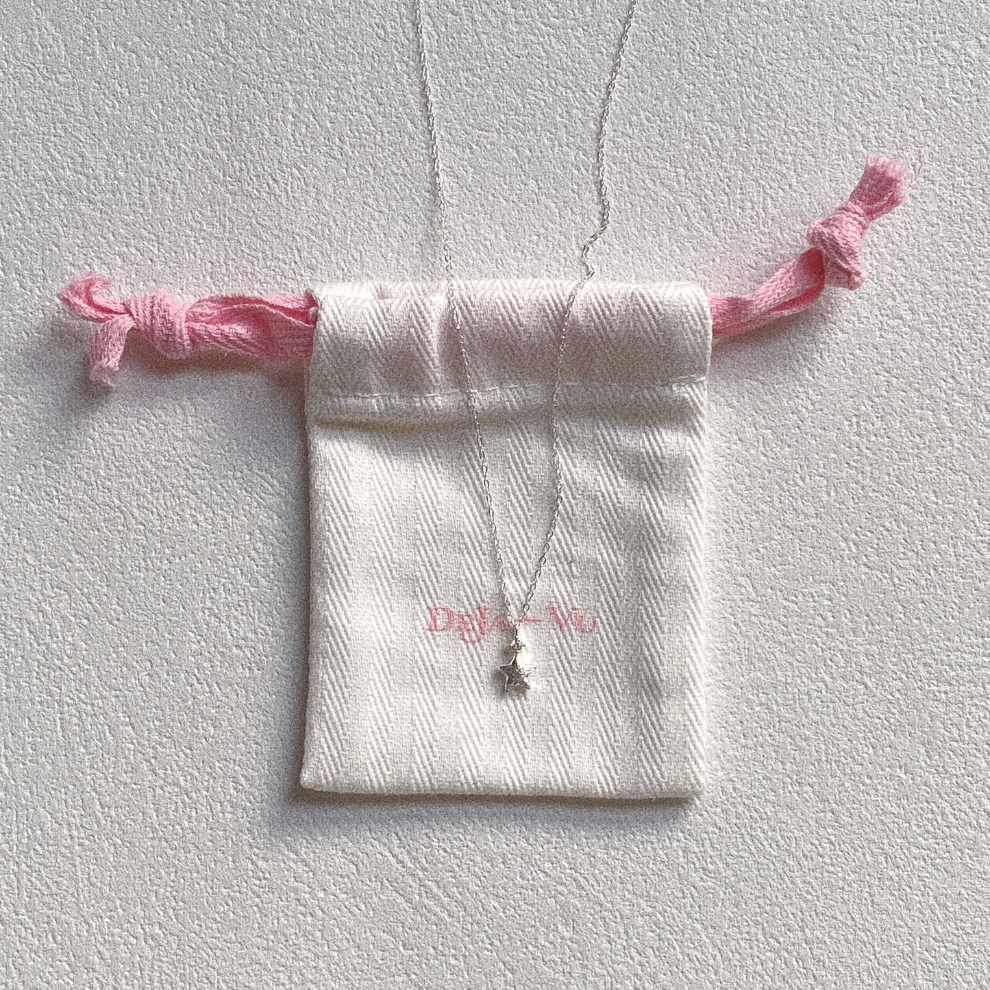 Dainty silver star necklace on Deja vu Jewellery pouch