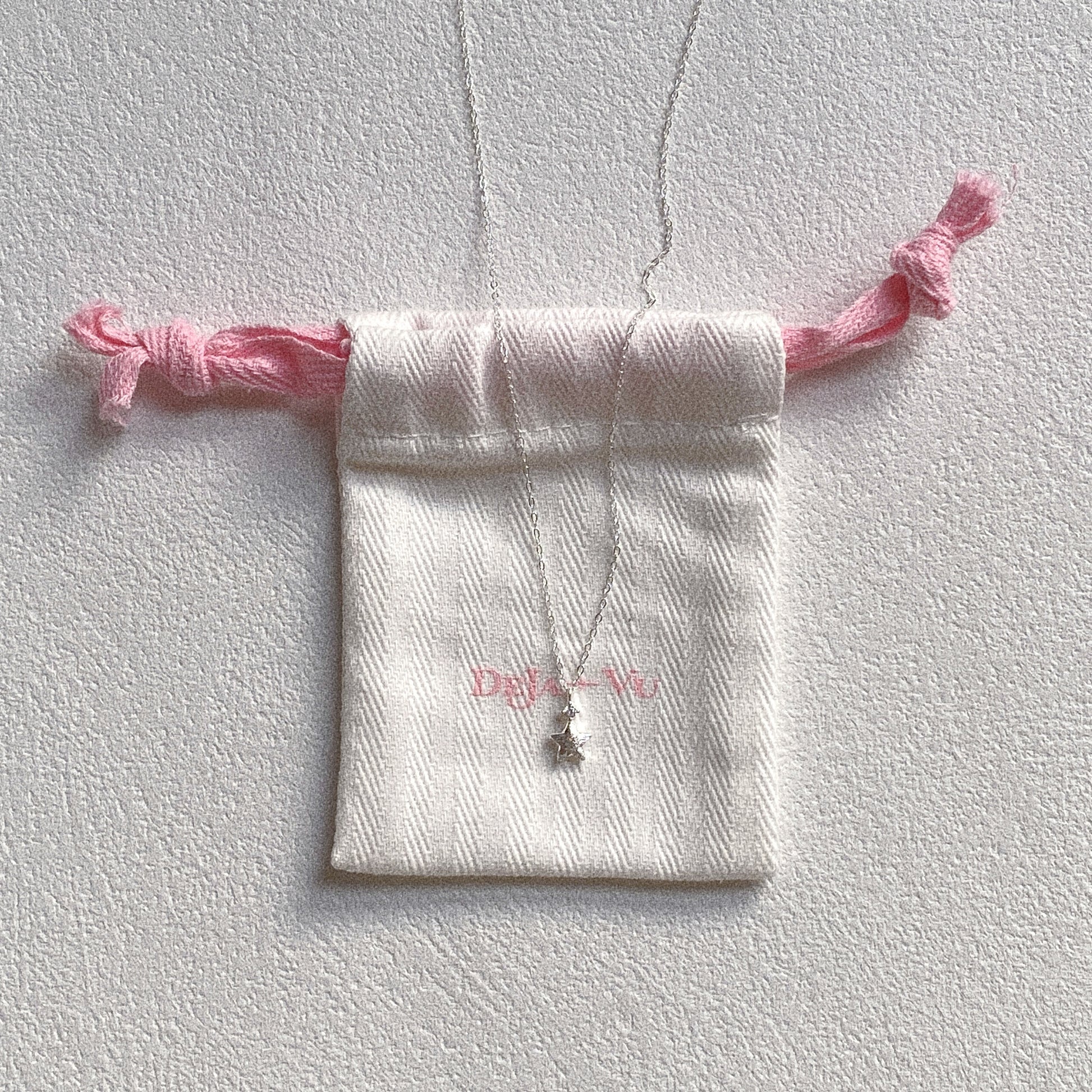 Dainty silver star necklace on Deja vu Jewellery pouch