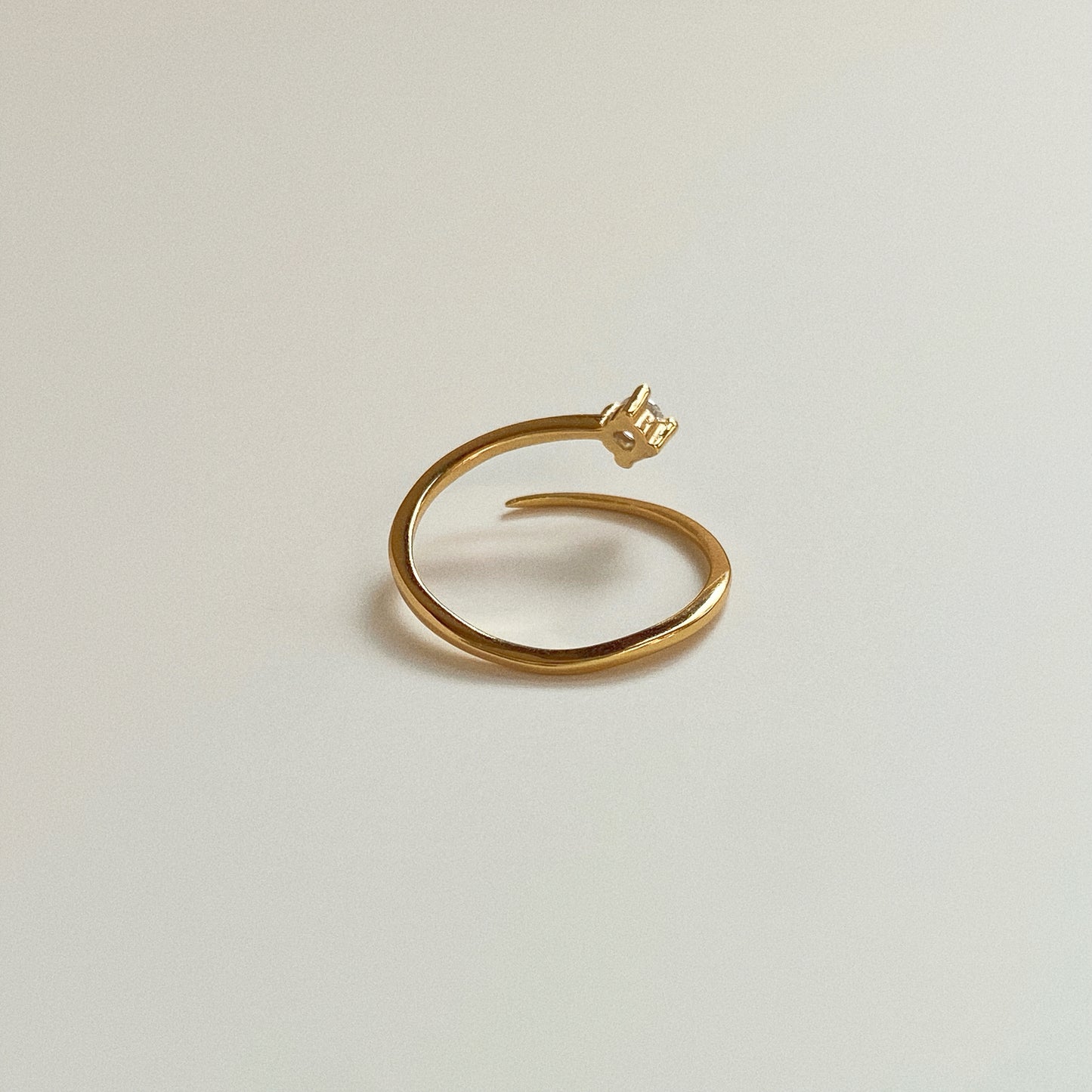 Side view of minimalist open wrap gold ring showing smooth adjustable 18k gold plated band