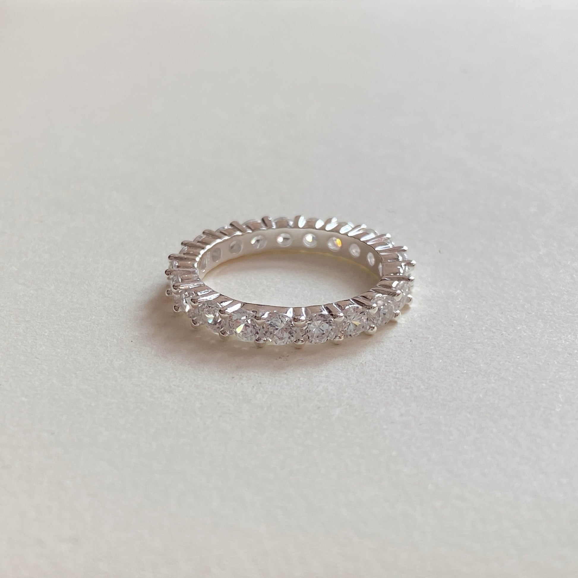 Angled product shot of sterling silver minimalist ring on white surface.