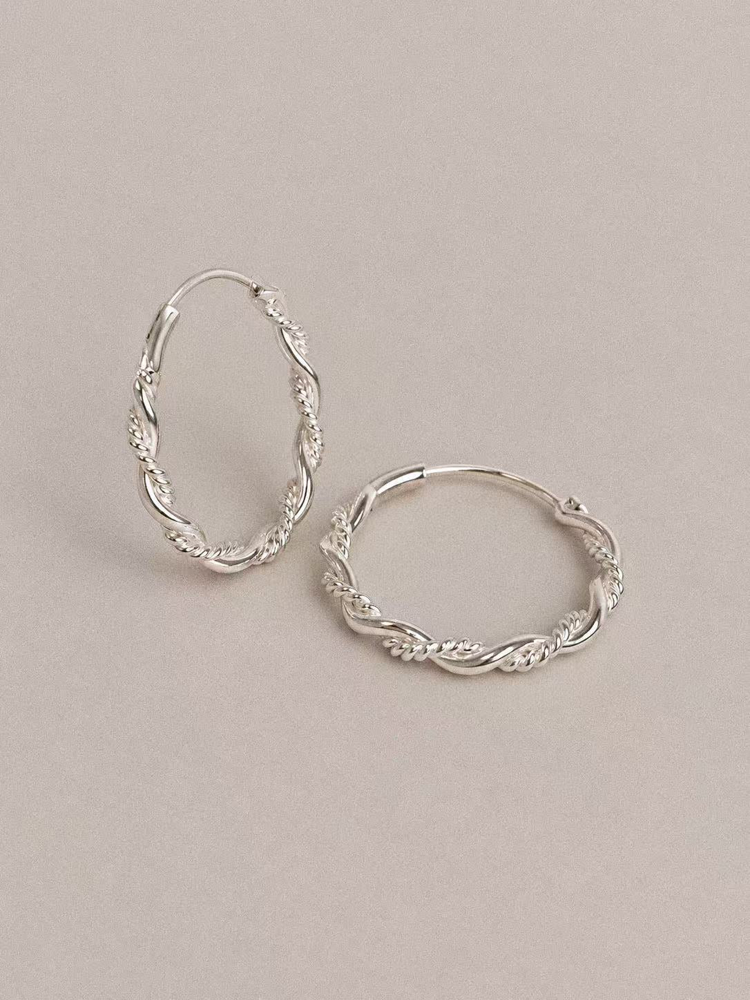 Close-up of the smooth and rope-textured twists on Mobius sterling silver hoop earrings