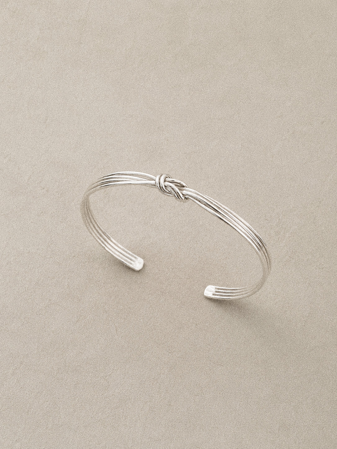Angled view of the multi strand wire bangle with the knot sitting at the centre of the band