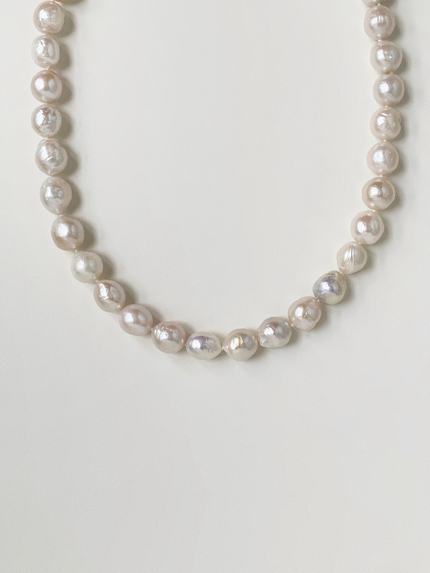 Close-up detail of natural baroque freshwater pearls showing organic shapes and deep mother-of-pearl lustre