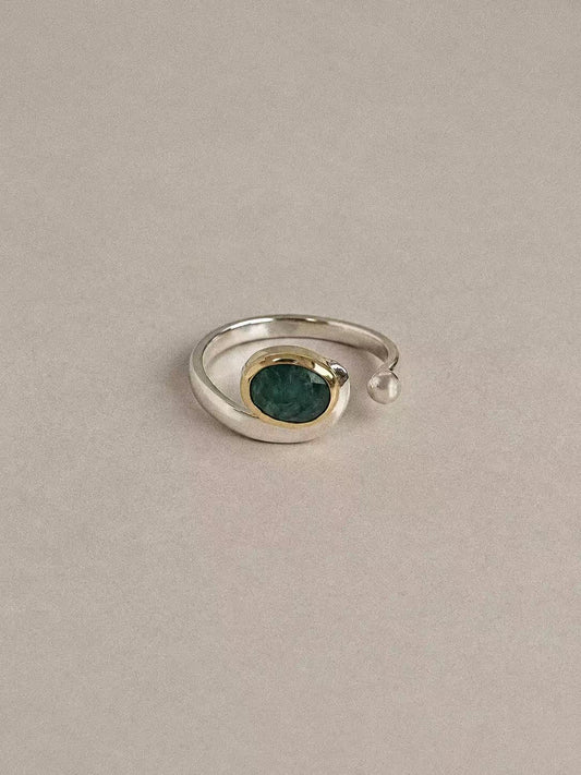 Natural emerald two-tone open ring with a sterling silver band and brass bezel, front view
