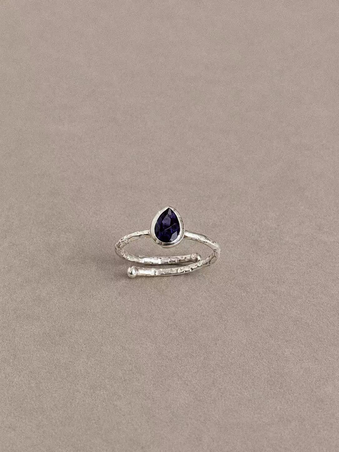 Natural iolite teardrop ring in 925 sterling silver with a textured overlapping band, front view