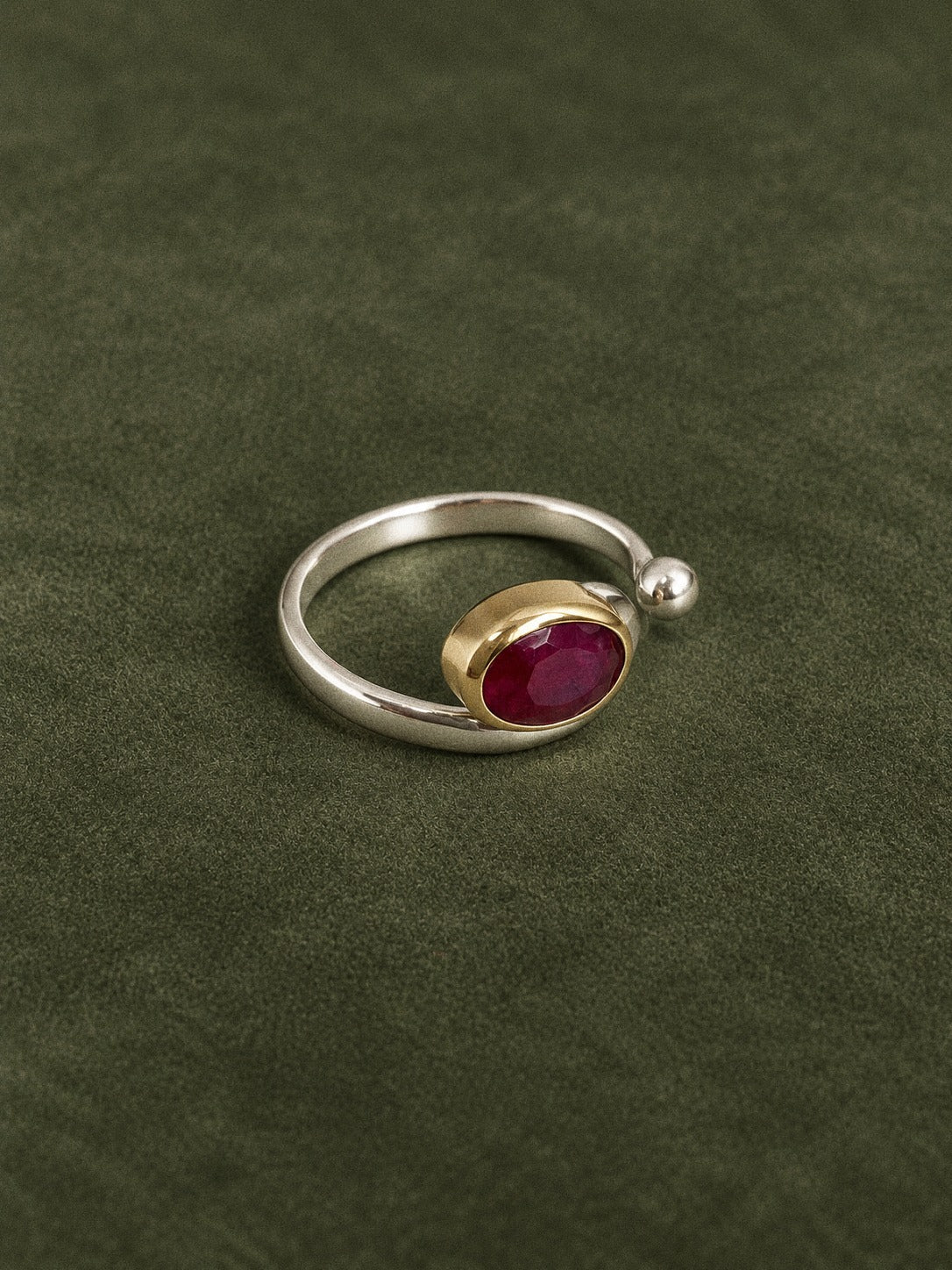 Handmade natural ruby open ring with a sterling silver band and brass bezel, angled front view