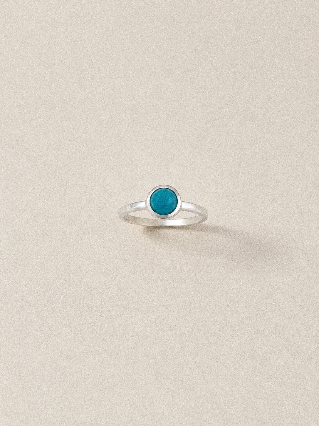 Front view of the Cove natural turquoise ring showing its blue cabochon, smooth bezel and slim sterling silver band.