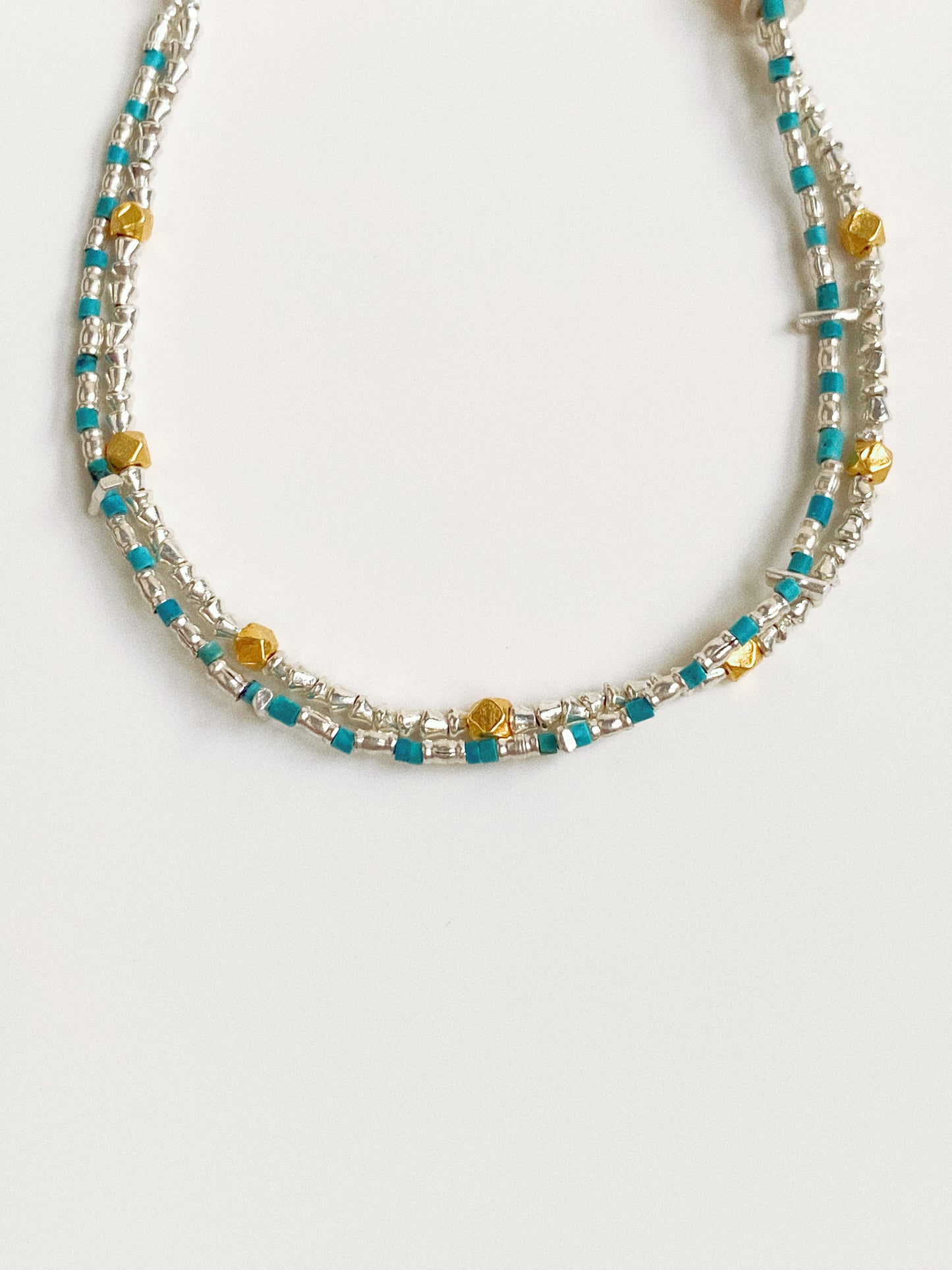 Close-up detail of natural turquoise discs, Thai silver nuggets and gold-plated accent beads on double-layer bracelet