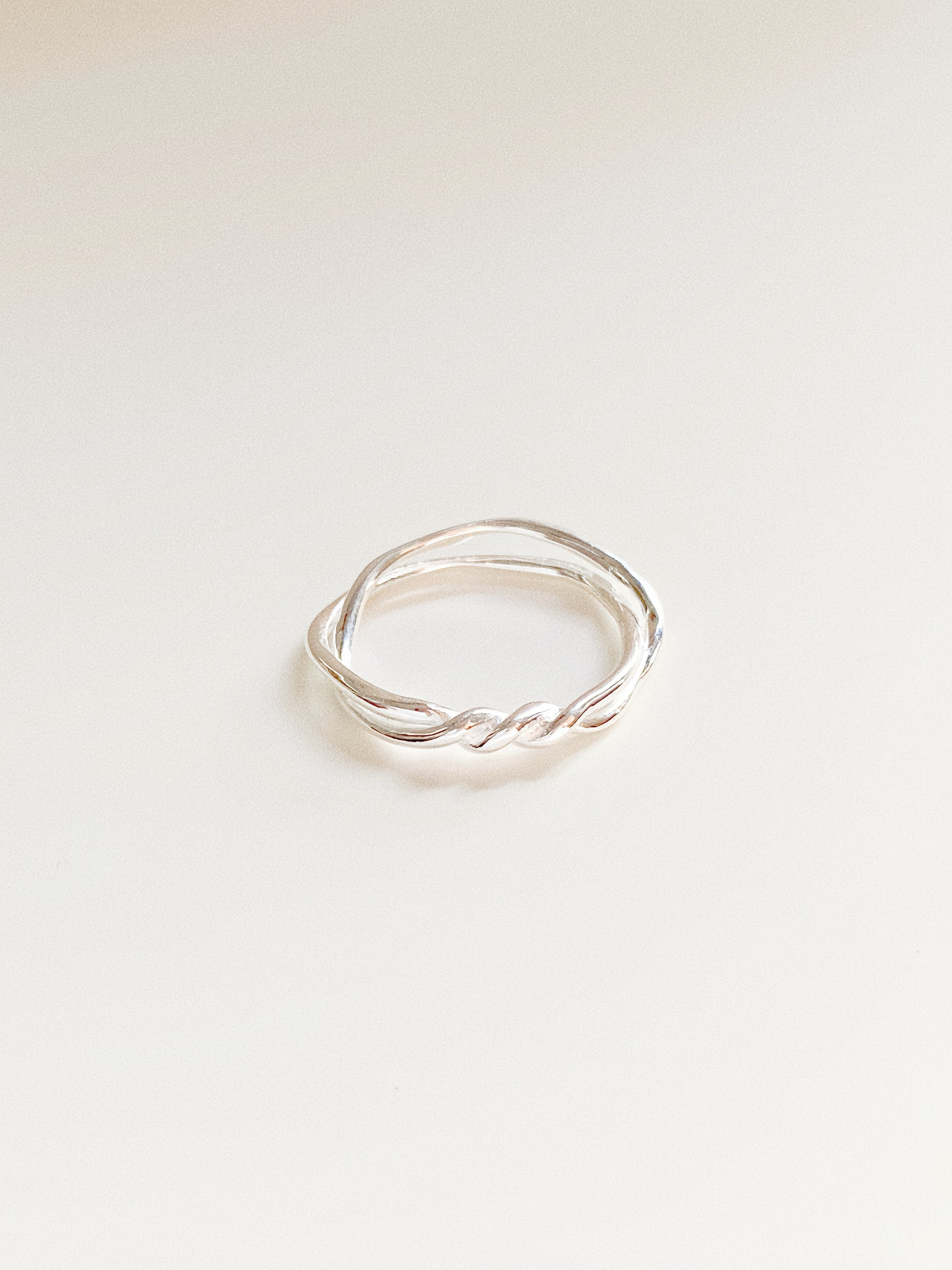 A high-angle shot highlighting the intricate nautical twist of the Twin Tide silver ring.