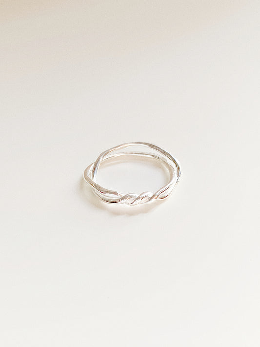 A high-angle shot highlighting the intricate nautical twist of the Twin Tide silver ring.