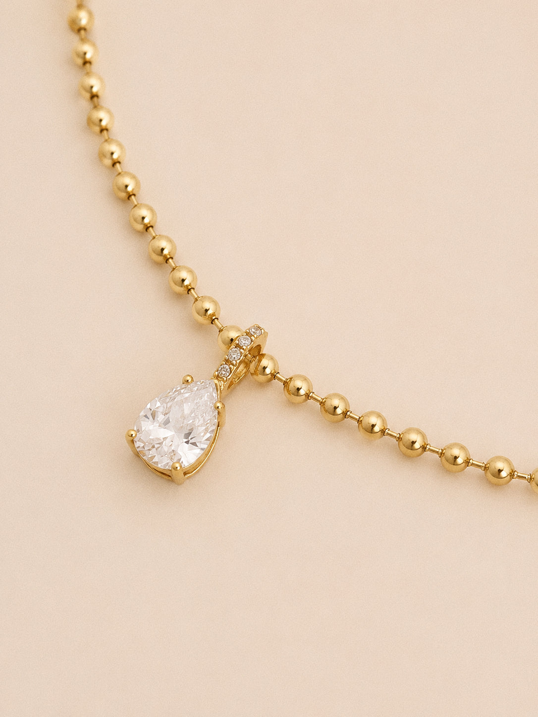 Close up of the pear cut cz pendant showing the crystal set bail and claw setting on the ball chain