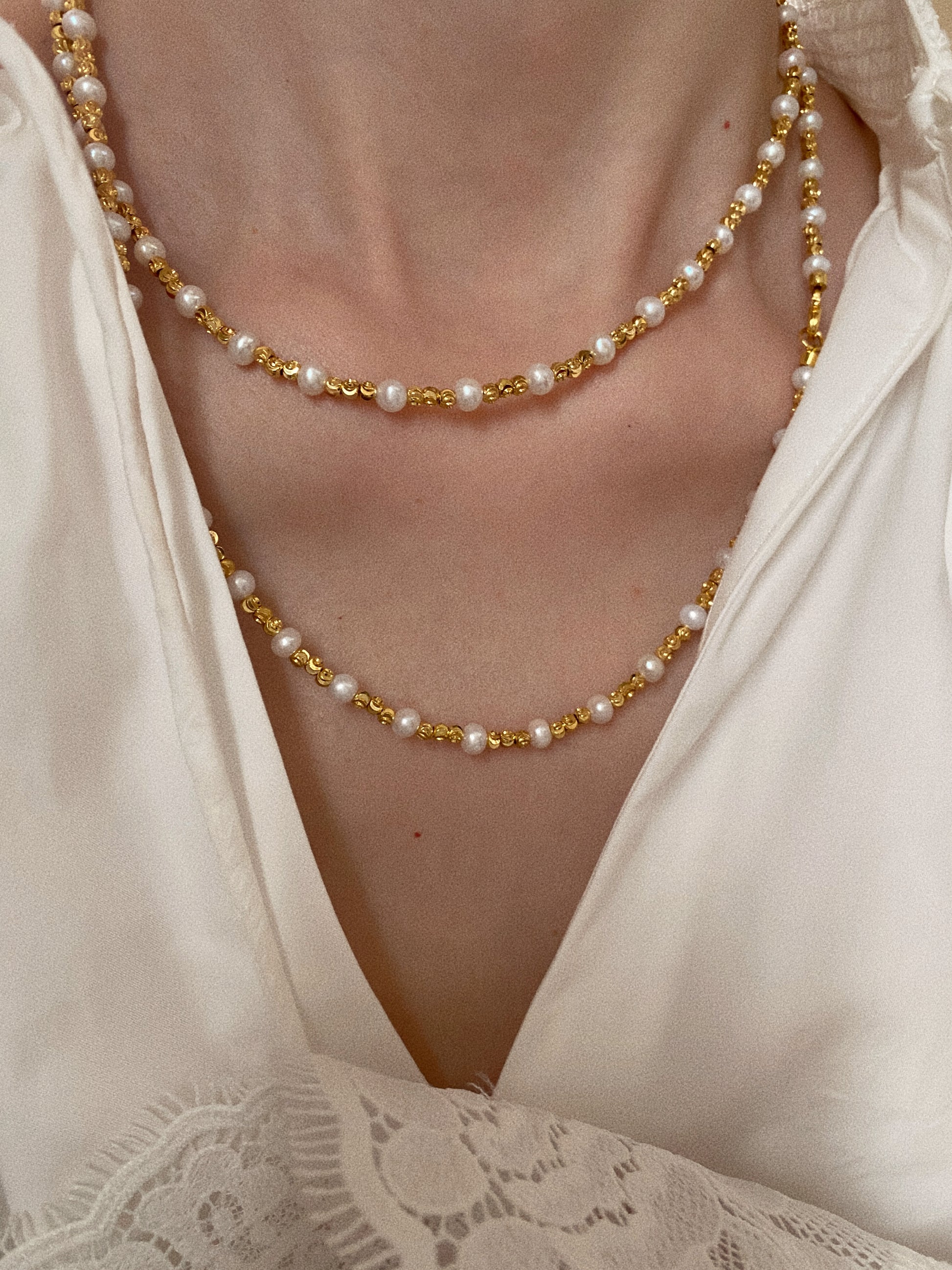 90cm pearl necklace styled doubled-up as a layered choker and collarbone necklace on model