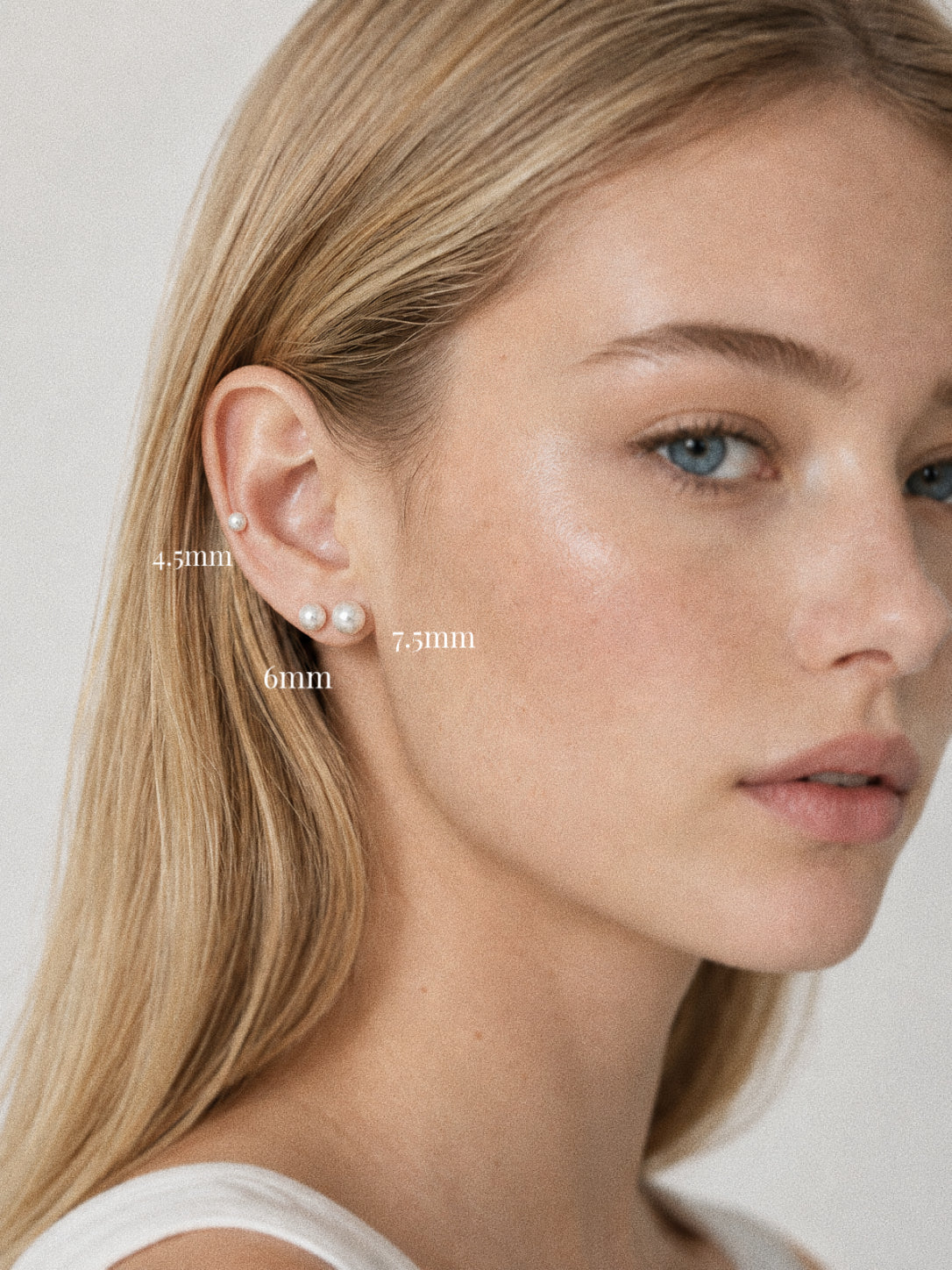 Pearl stud earrings worn on the ear in 4.5 mm, 6 mm and 7.5 mm, showing how each size sits across lobe and cartilage.