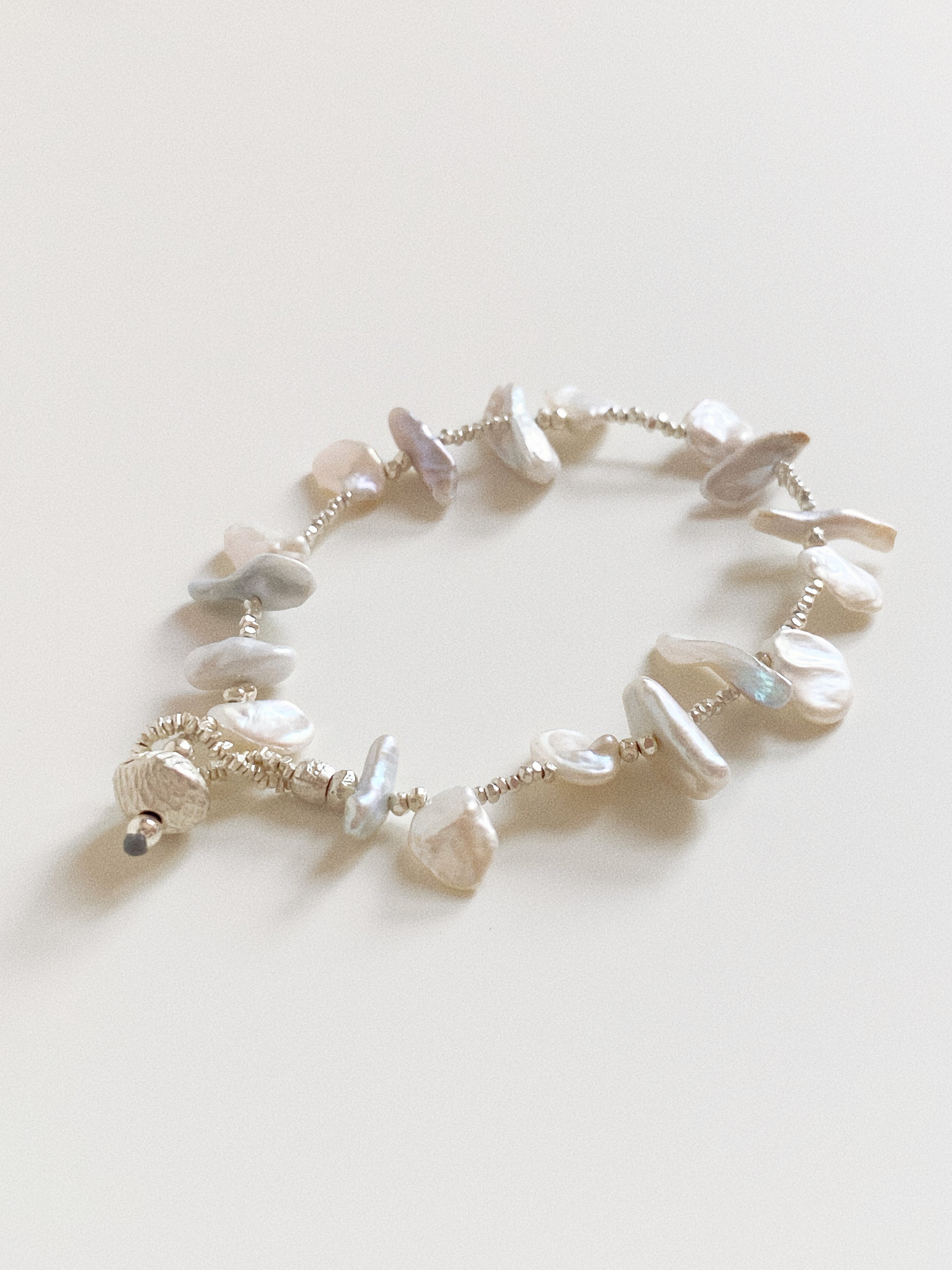 Handmade 925 sterling silver bracelet featuring natural baroque petal pearls and small silver spacer beads.