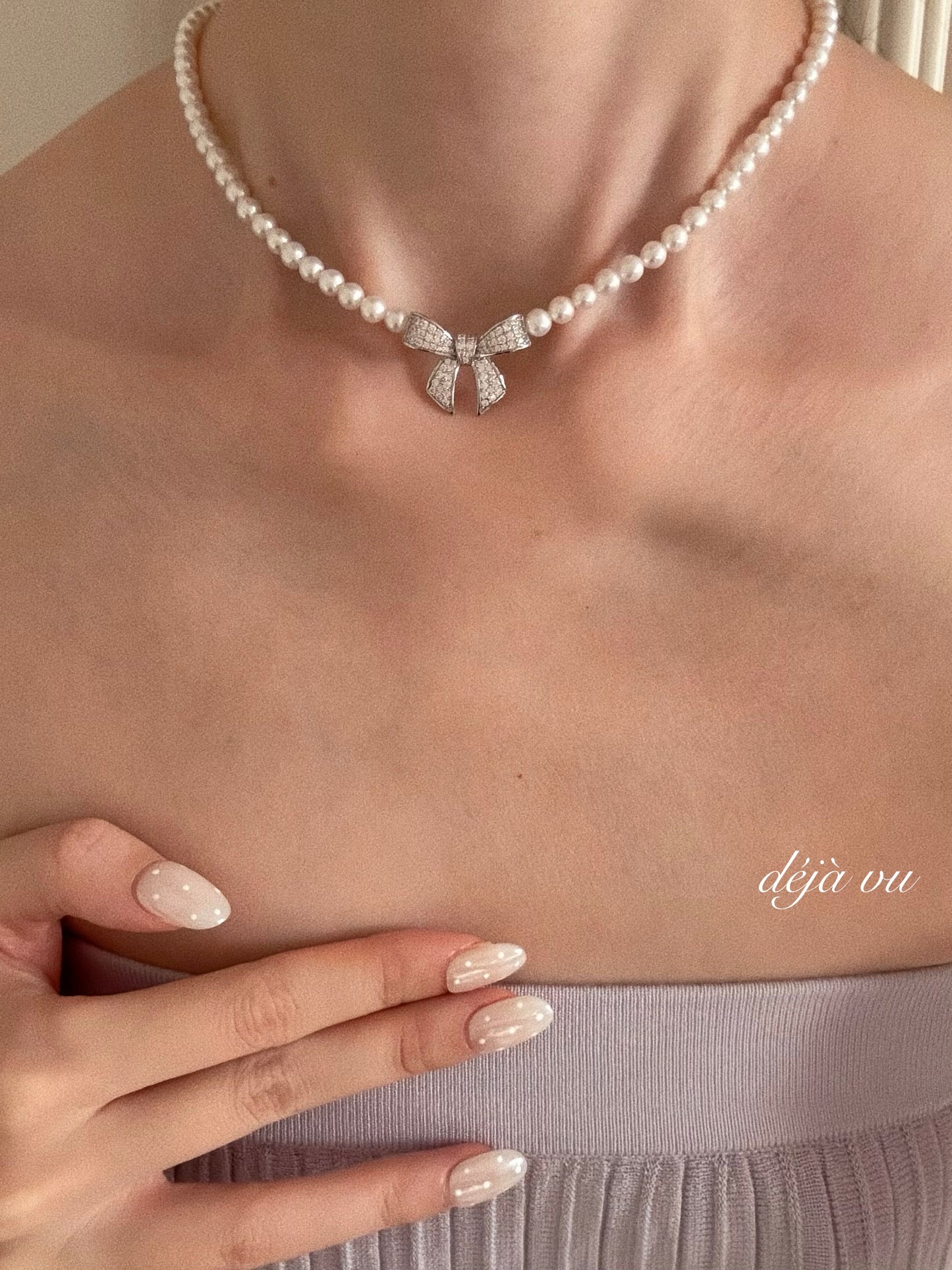 Model wearing the Coquette Bow Pearl Necklace, featuring natural freshwater pearls and a sparkling crystal bow.