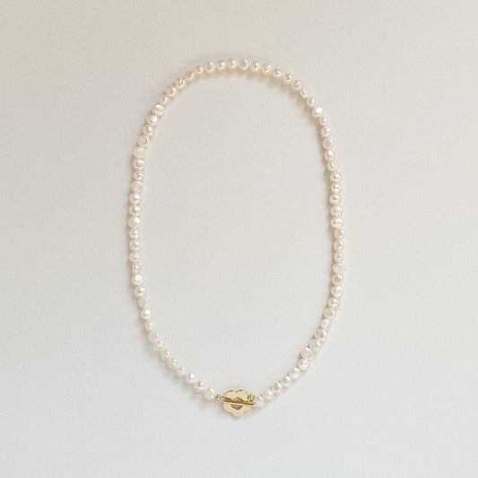 Full view of Bloom Toggle freshwater pearl necklace laid in a circle with flower clasp at the front