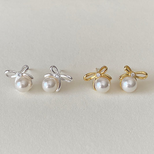 Bow pearl studs in gold and sterling silver side-by-side, small dainty pearl earrings