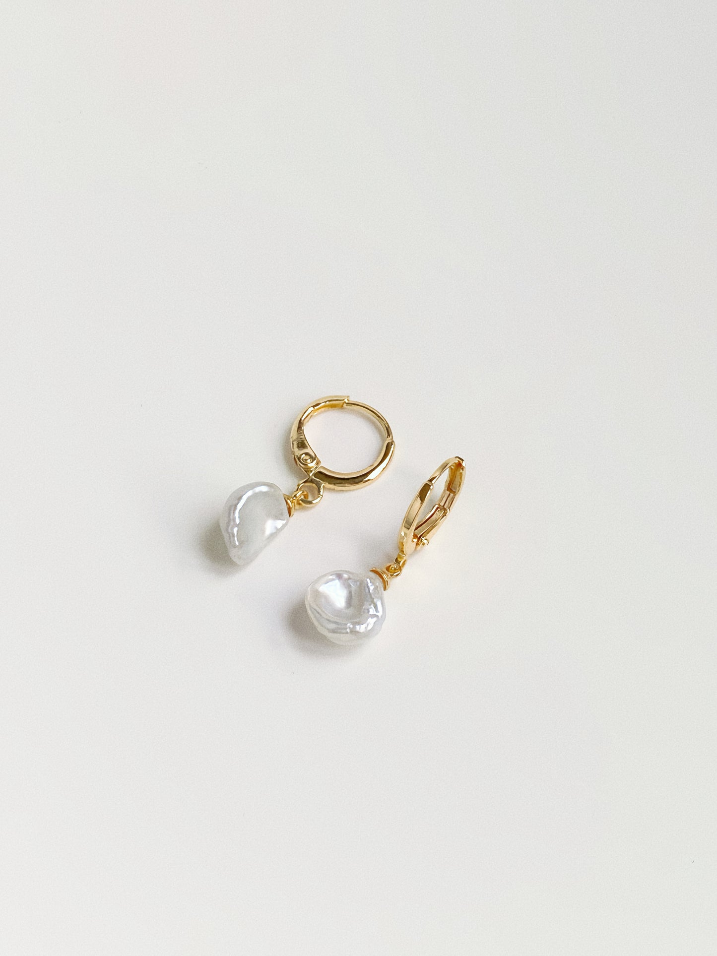 Petal baroque freshwater pearl huggie hoop earrings in gold by Deja Vu Jewellery flat lay