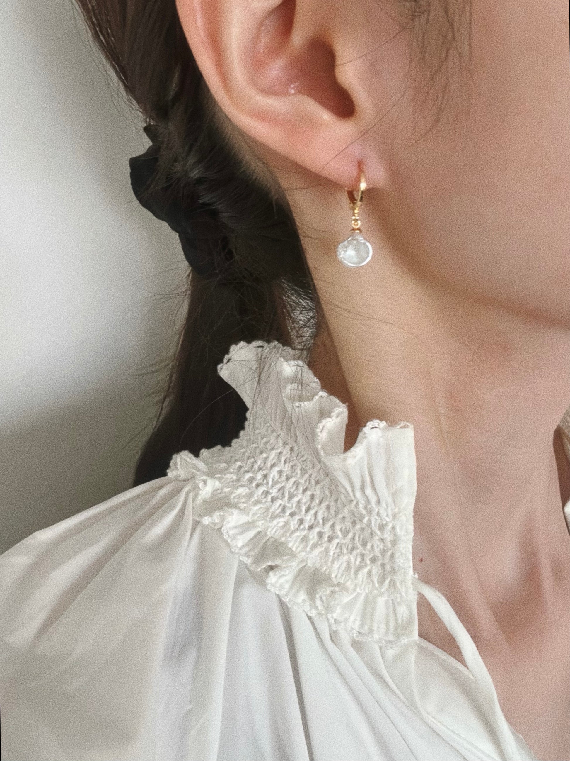 Petal pearl drop huggie hoop earring styled on model with white blouse for everyday wear