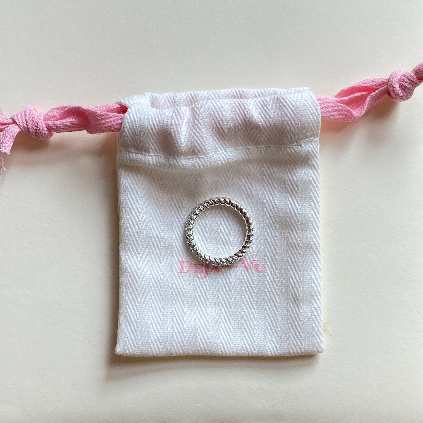 Micro pavé statement ring resting on a Deja vu jewellery pink-trim pouch, polished sterling silver finish.