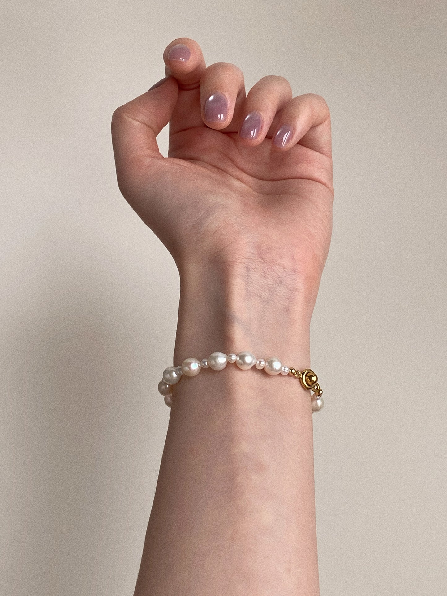 Real freshwater pearl bracelet styled on a woman's wrist with gold-plated clasp by Deja Vu Jewellery