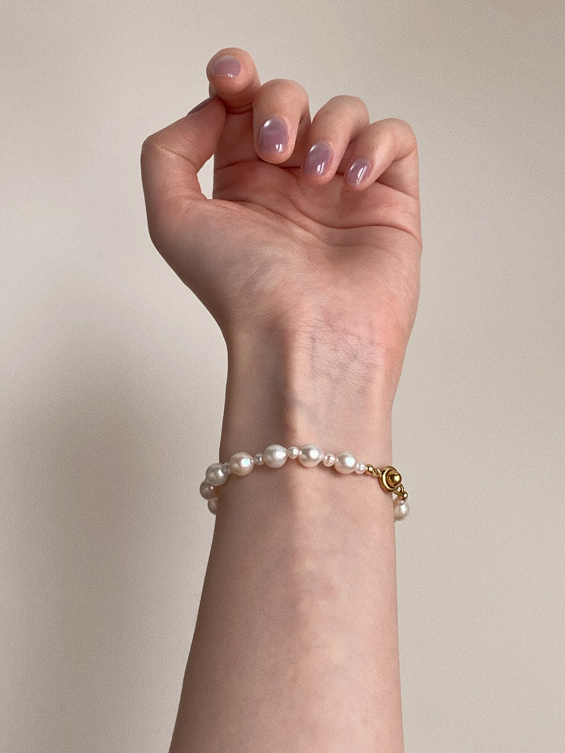 Real freshwater pearl bracelet styled on a woman's wrist with gold-plated clasp by Deja Vu Jewellery