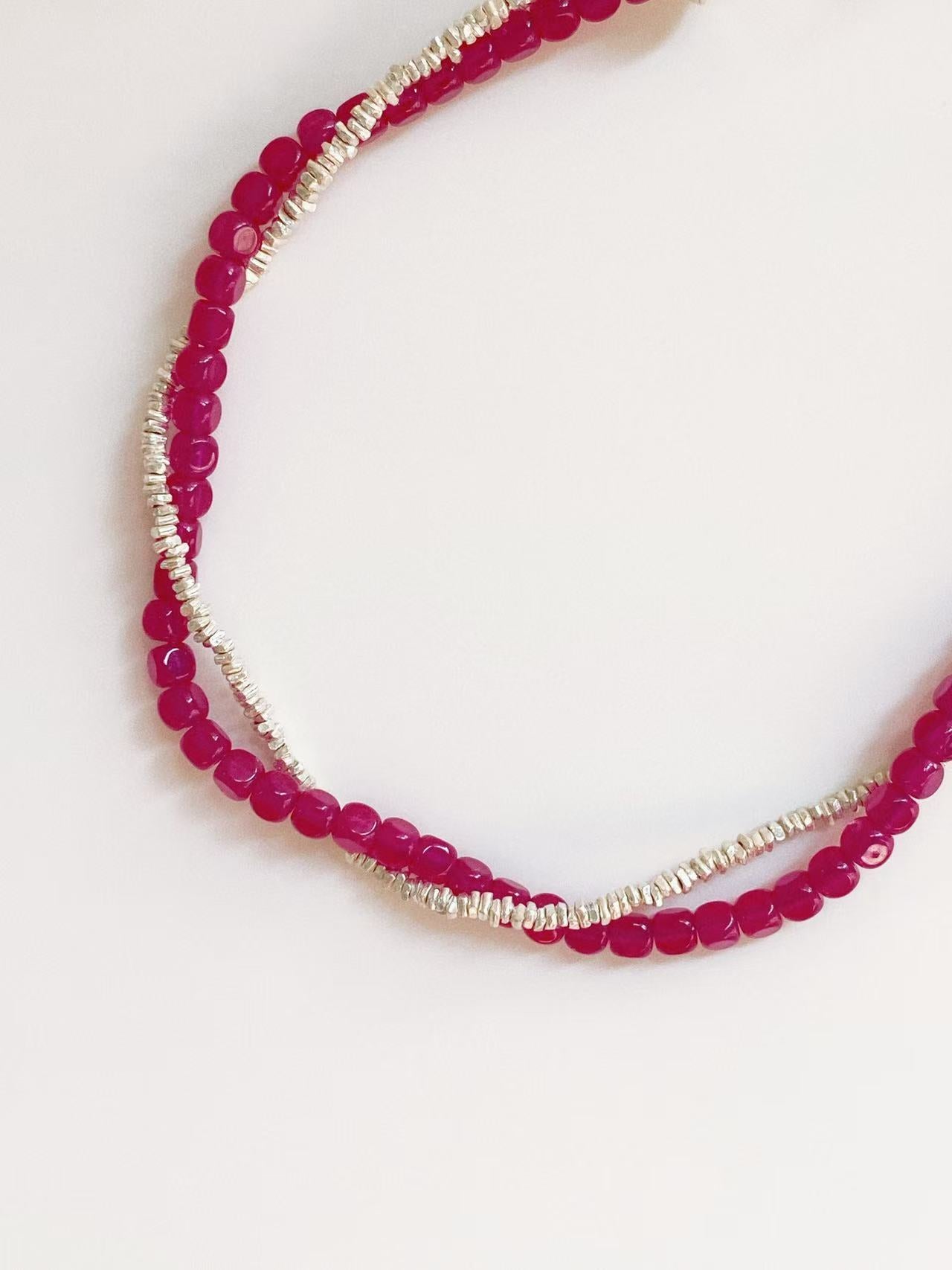 Macro view of the double-layer design featuring vibrant pink-red corundum beads and handcrafted irregular Thai silver grains for a modern fashion look.