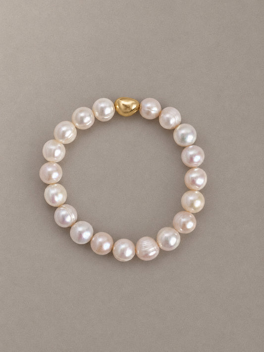 Ripple baroque pearl stretch bracelet with rounded, naturally ringed pearls and a single gold-tone accent bead.