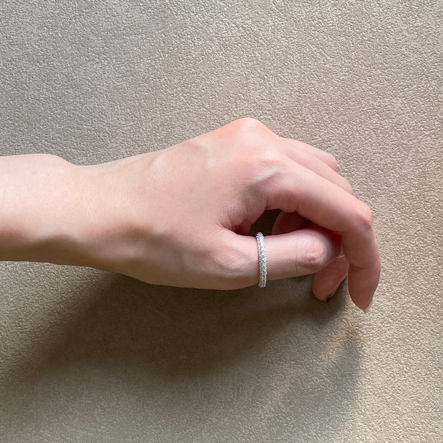 Side view of the slim pavé silver ring on hand, highlighting the low-set, snag-safe profile.