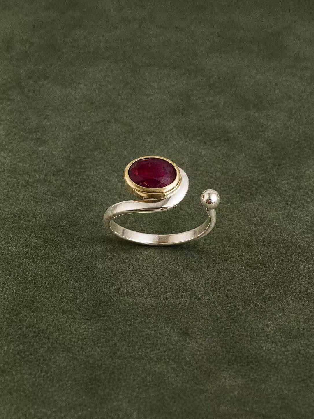 Side view of the raised ruby setting and curved open sterling silver band