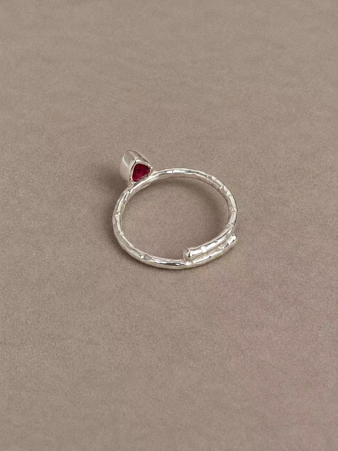 Back view of the ruby teardrop ring showing the textured sterling silver band and overlapping ends
