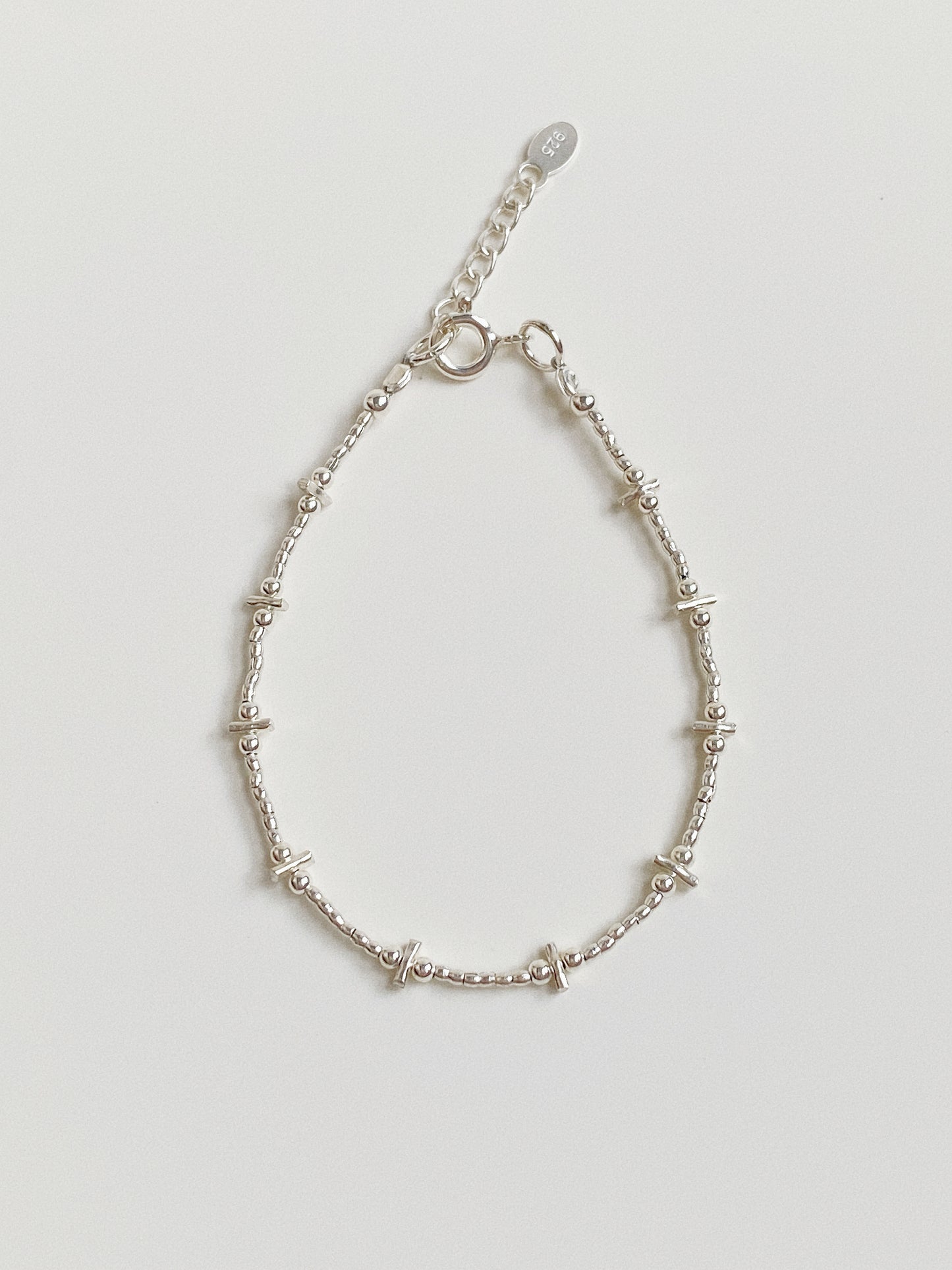 Flat lay of a handmade 925 sterling silver bracelet featuring a bar and bead design, approx 1.7g weight.