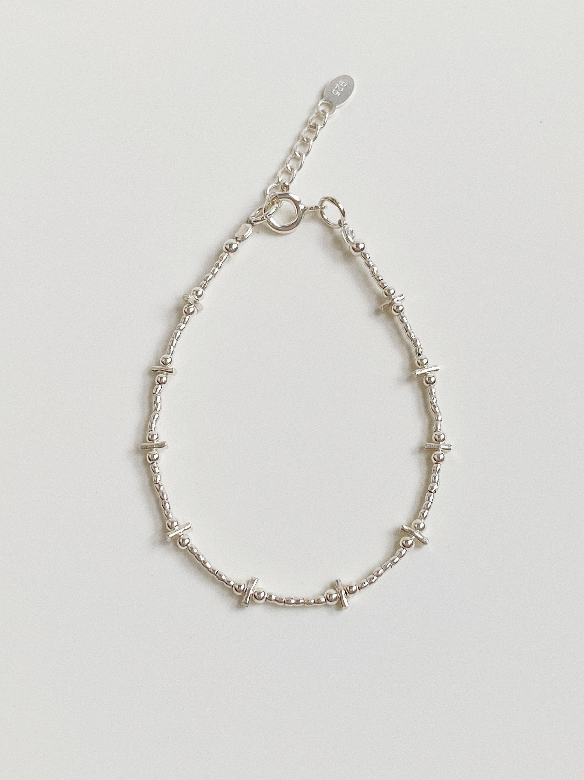 Flat lay of a handmade 925 sterling silver bracelet featuring a bar and bead design, approx 1.7g weight.