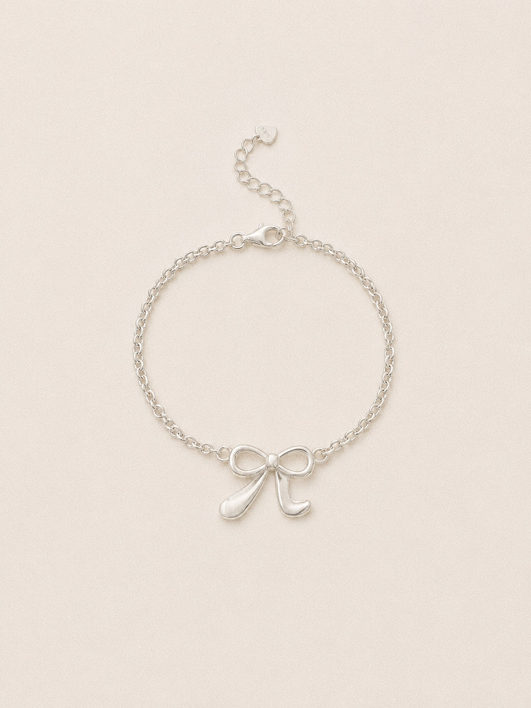 Ballet bow bracelet in 925 sterling silver, a sculpted ribbon bow on a fine belcher chain with a lobster clasp.