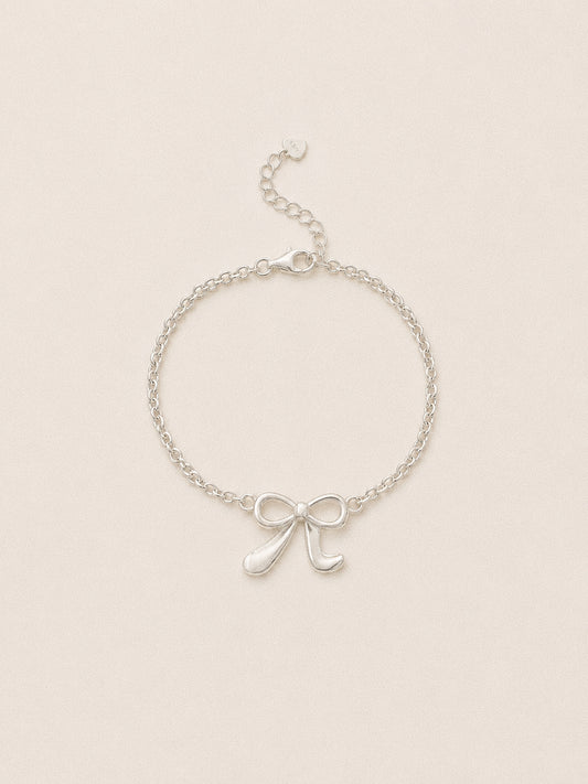 Ballet bow bracelet in 925 sterling silver, a sculpted ribbon bow on a fine belcher chain with a lobster clasp.