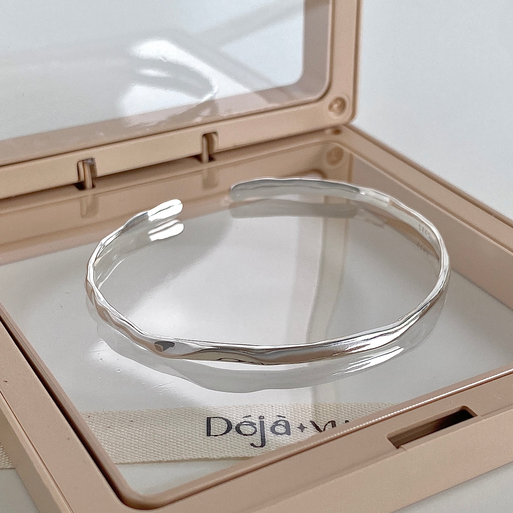 Faceted 925 silver cuff bangle in a jewellery case showing the soft hammered texture catching the light