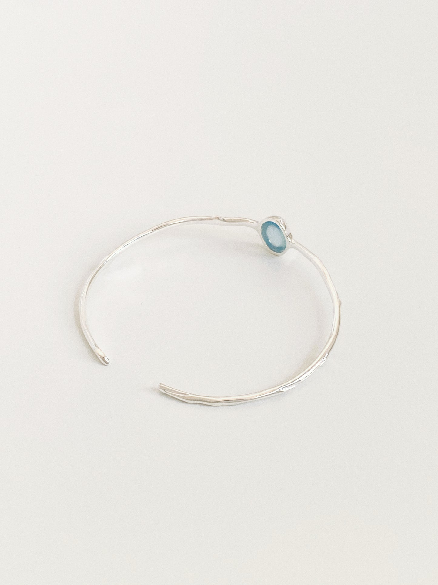 Rivage silver cuff bangle showing the open back design and irregular hammered band texture