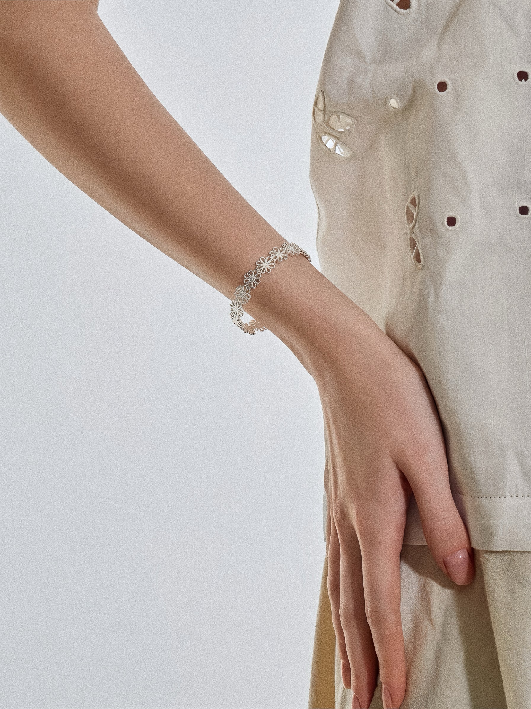 Silver daisy lace open cuff bracelet styled on wrist showing 7mm band and delicate floral detail