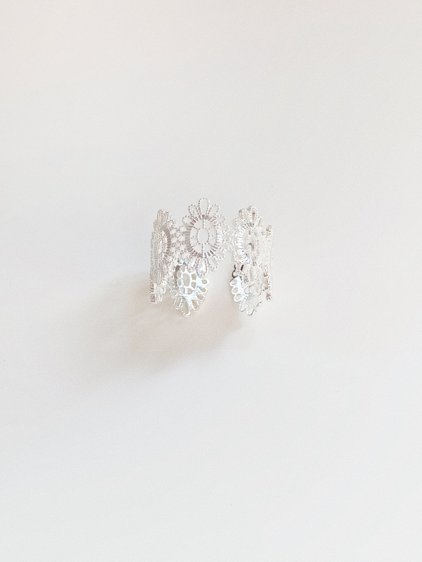 Silver vintage lace adjustable ring showing floral pattern and open-back band