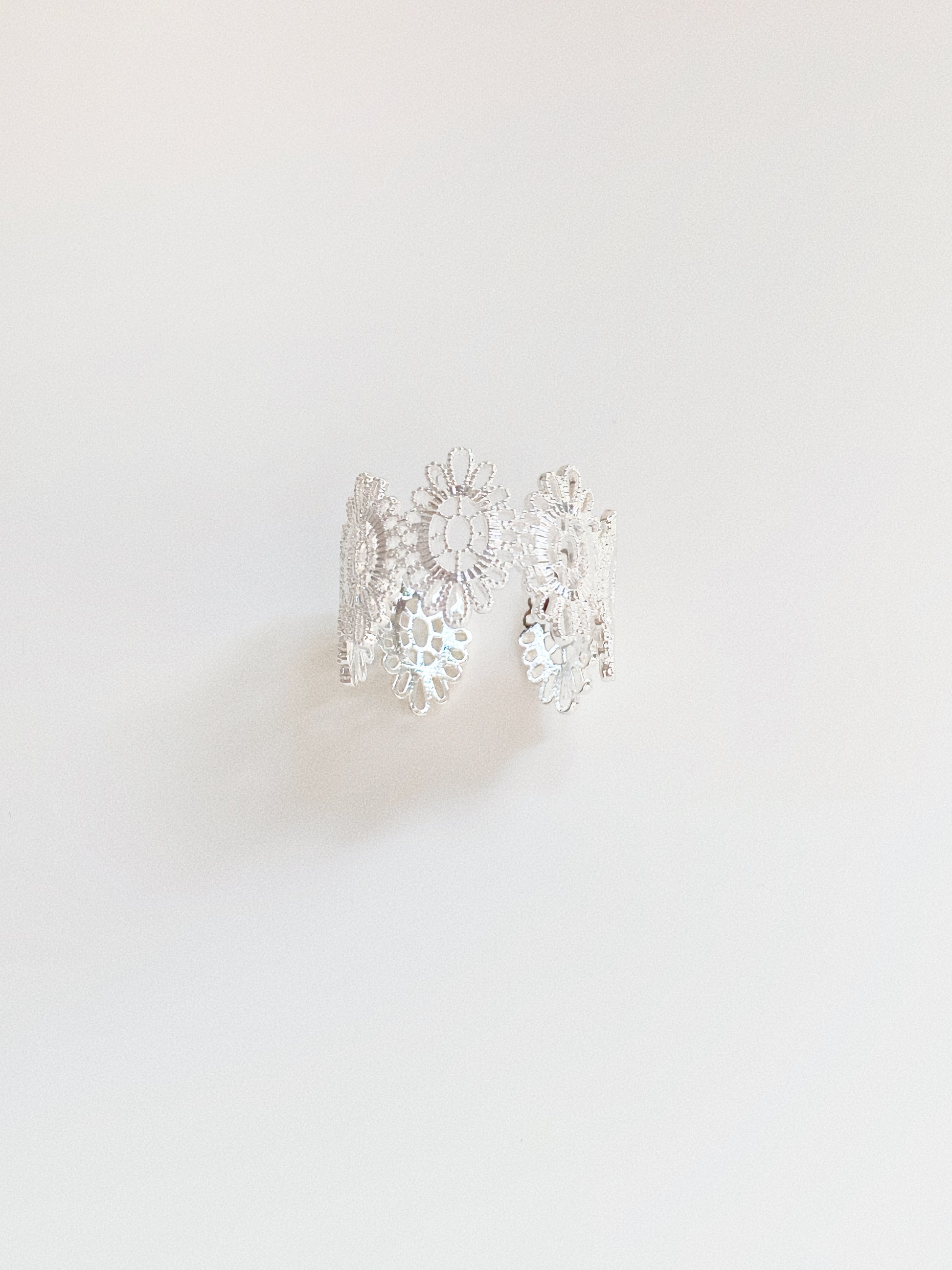 Silver vintage lace adjustable ring showing floral pattern and open-back band