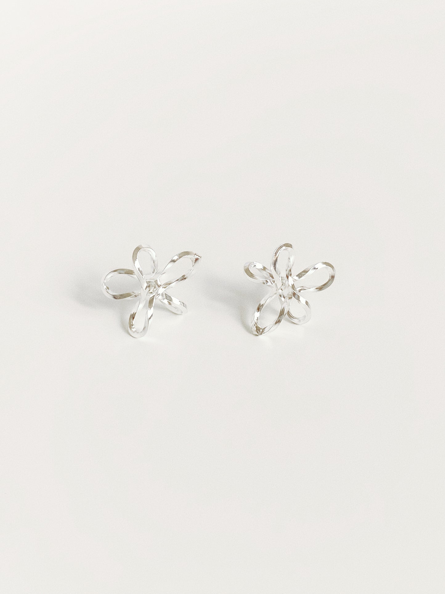 925 sterling silver wire flower stud earrings showing sketched-line floral silhouette and faceted finish