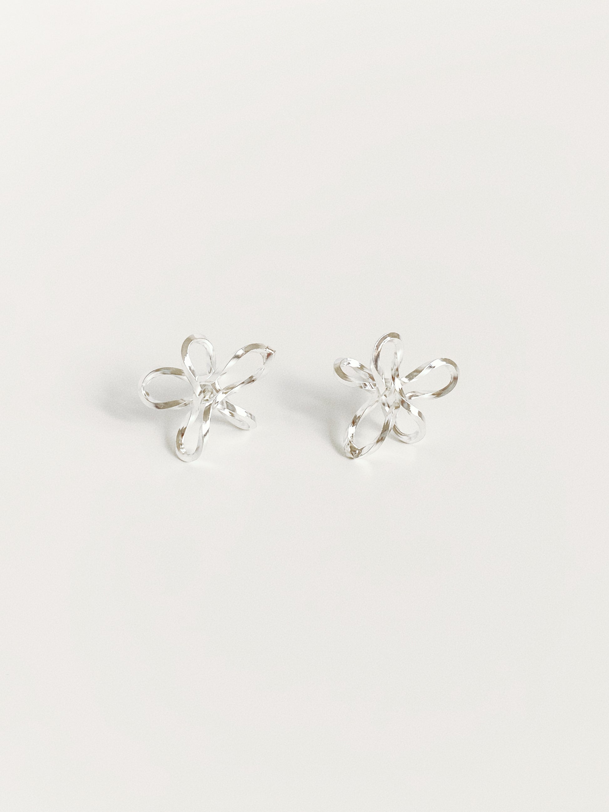 925 sterling silver wire flower stud earrings showing sketched-line floral silhouette and faceted finish