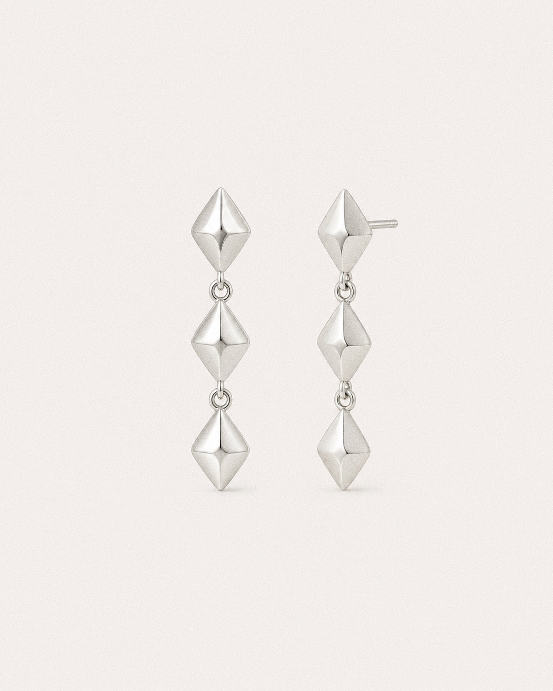 Silver star drop earrings in 925 sterling silver, cut planes catching light down the length of the drop.