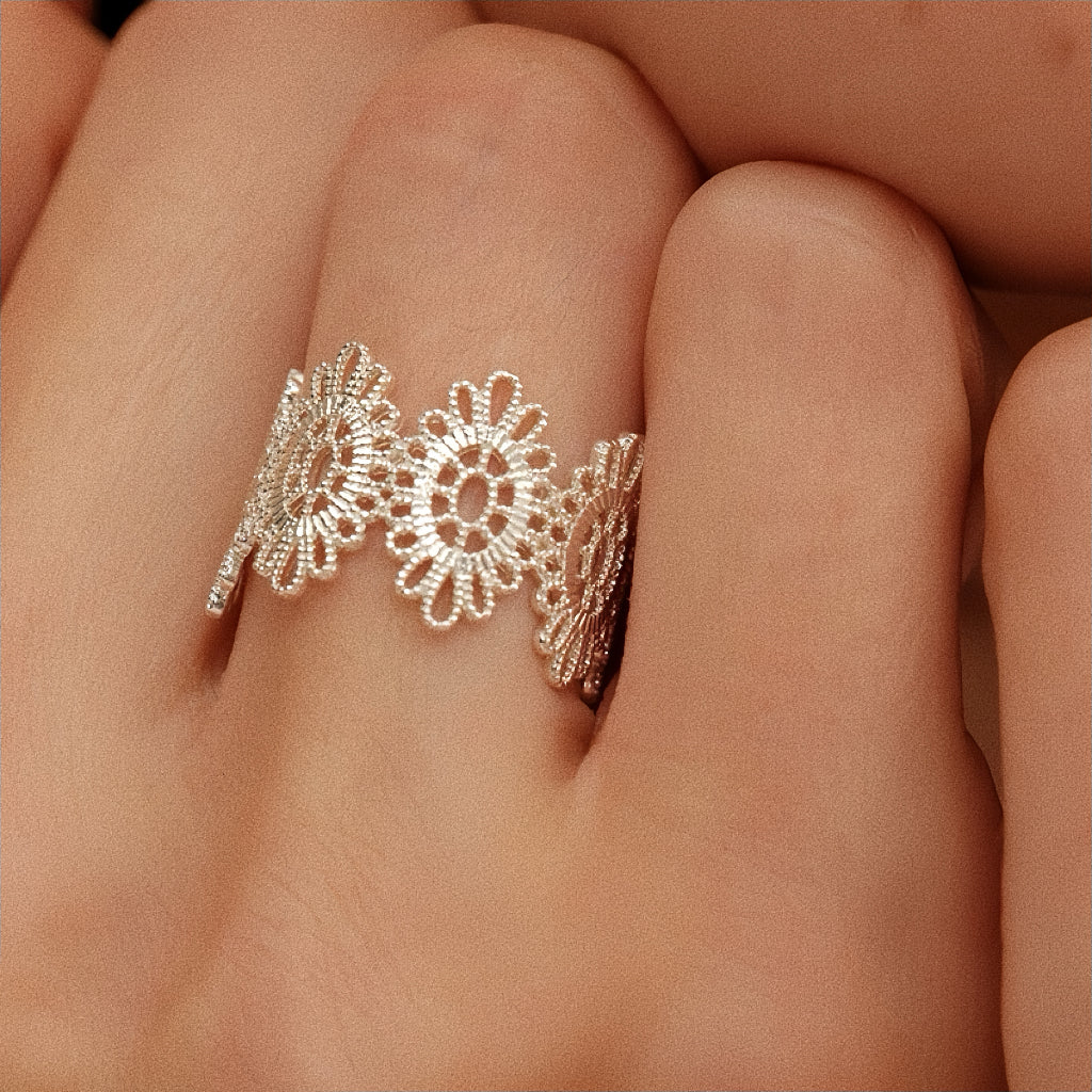Silver vintage lace floral ring worn on finger close-up showing lacework texture