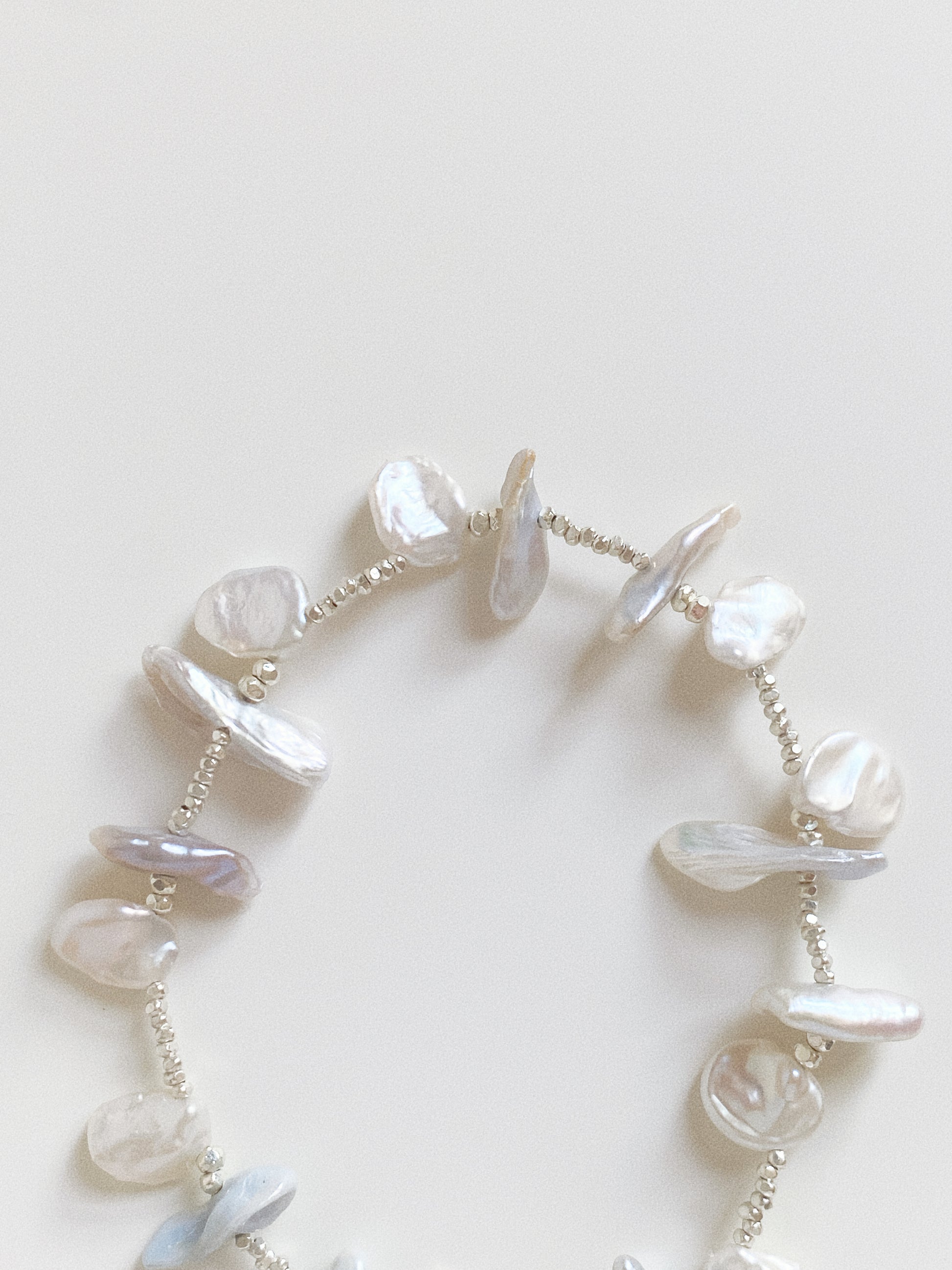Close up detail of organic Keshi pearls with high luster, spaced with sterling silver beads on a handmade bracelet.